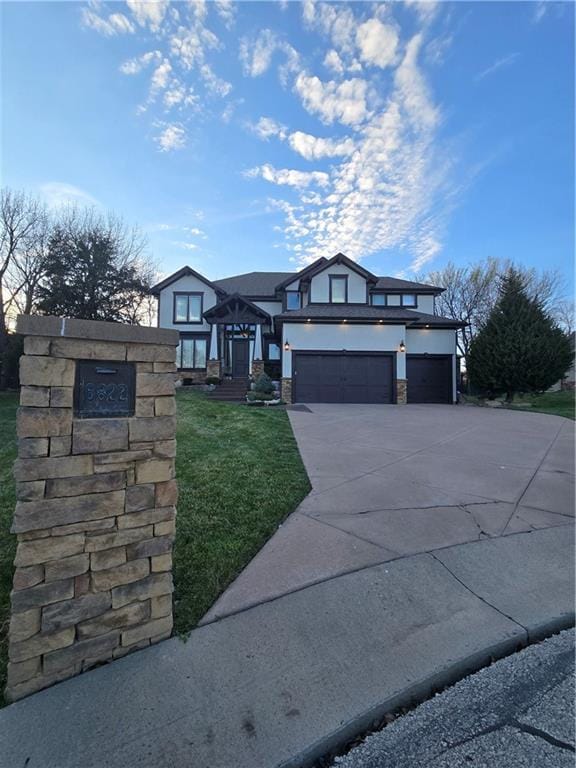 view of front of house featuring a garage, concrete driveway, stucco siding, and a front lawn