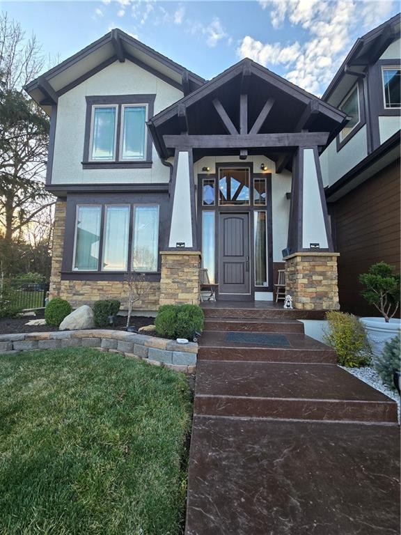 entrance to property with stone siding and stucco siding