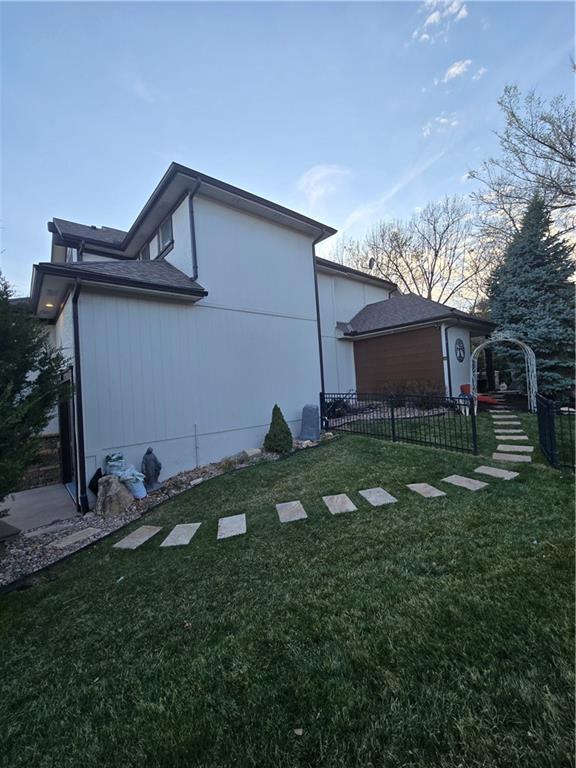 view of side of property with fence and a yard