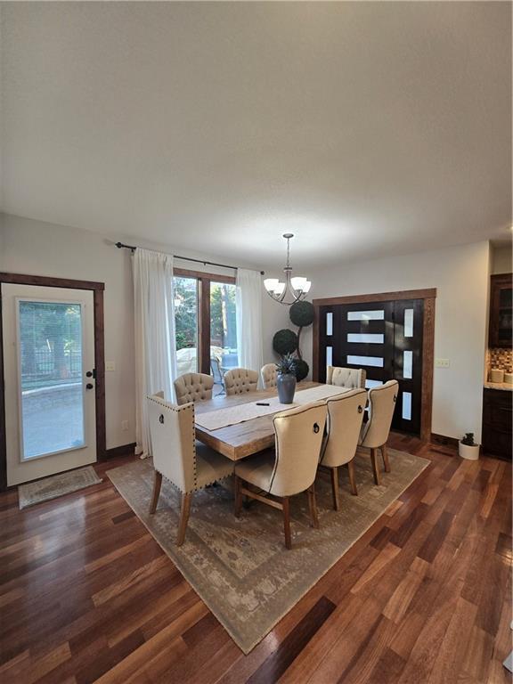 dining room with dark wood finished floors, baseboards, and a notable chandelier