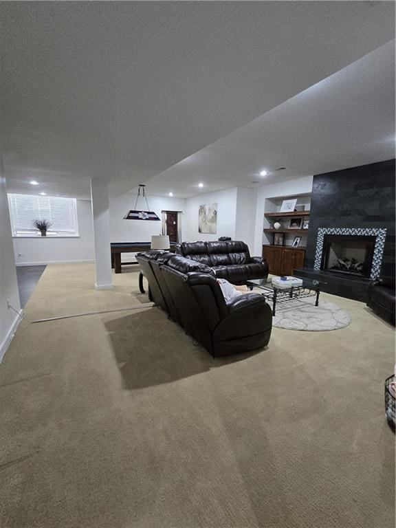 carpeted living room featuring a textured ceiling, a fireplace, and baseboards
