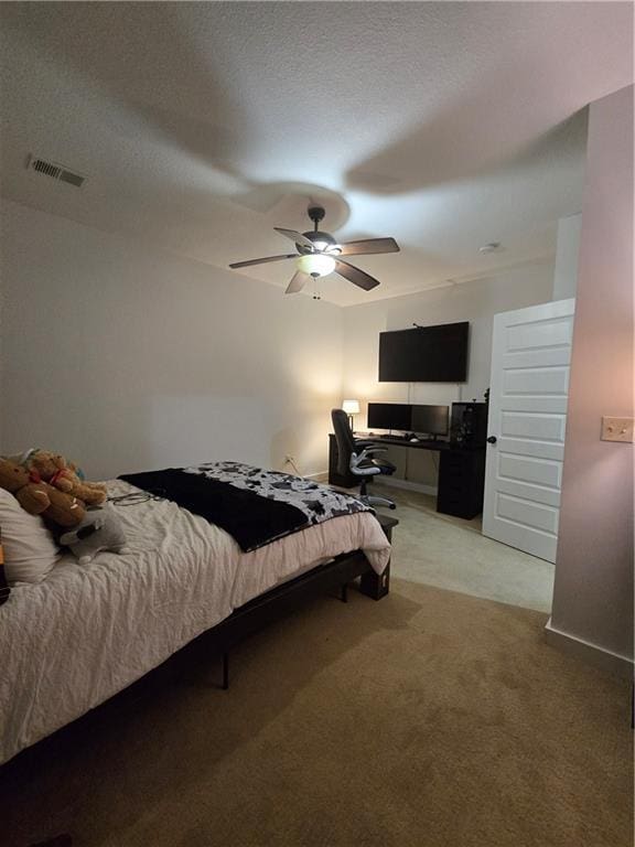 bedroom featuring a textured ceiling, visible vents, baseboards, a ceiling fan, and light colored carpet