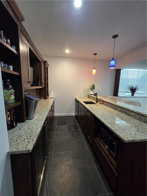 kitchen with open shelves, baseboards, a sink, light stone counters, and a peninsula