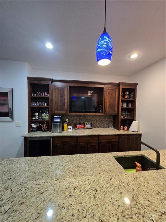 bar with a sink, decorative backsplash, decorative light fixtures, a dry bar, and recessed lighting