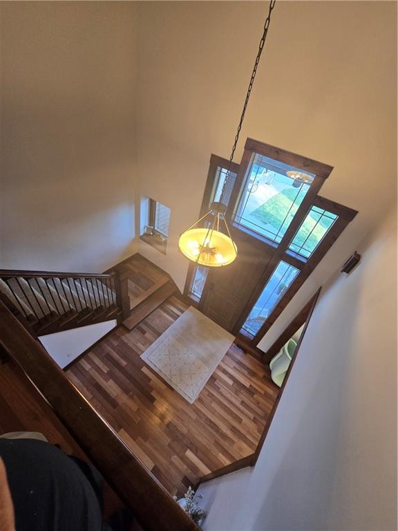 stairs featuring wood finished floors and a towering ceiling