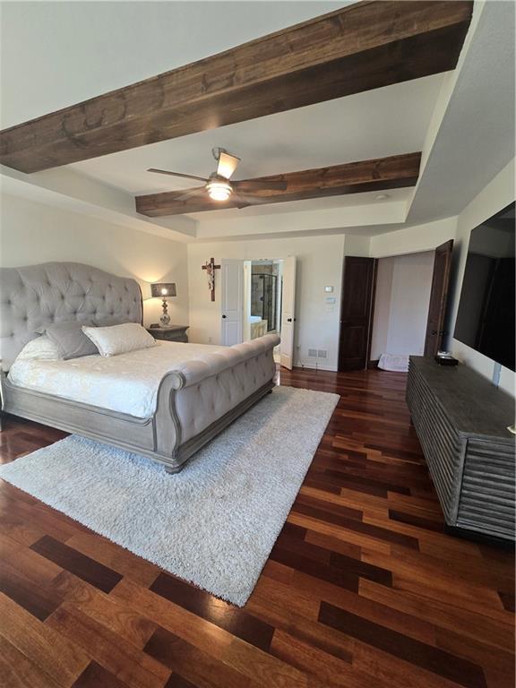 bedroom featuring ceiling fan, visible vents, wood finished floors, and beam ceiling