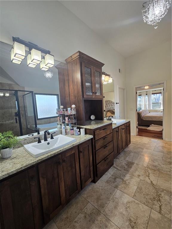 ensuite bathroom featuring a shower stall, a washtub, ensuite bath, and a chandelier