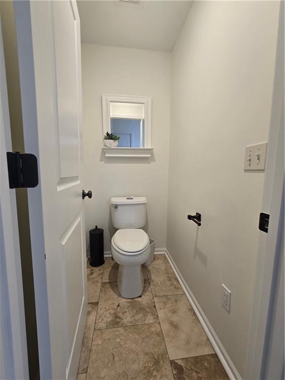 bathroom with toilet and baseboards
