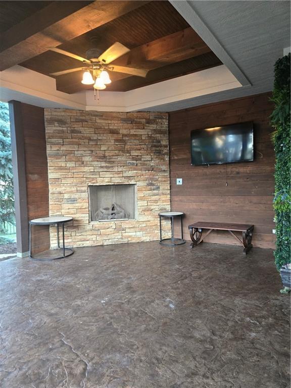 view of patio featuring an outdoor stone fireplace and ceiling fan