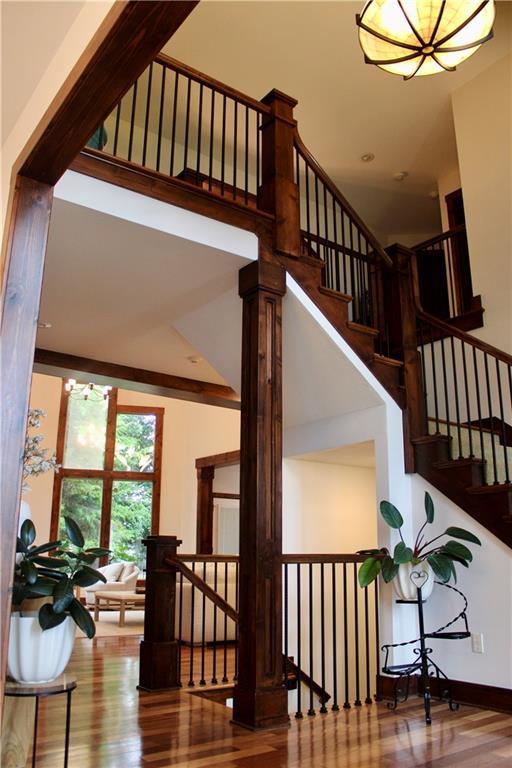 6822 Woodstock Ct, Shawnee, KS 66218 - staircase with wood finished floors and a chandelier