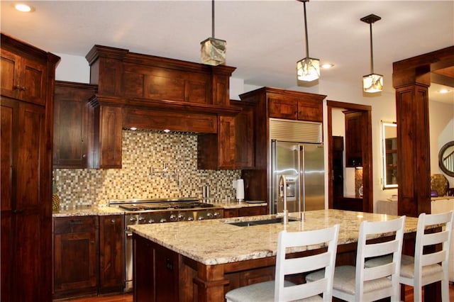 6822 Woodstock Ct, Shawnee, KS 66218 - kitchen featuring high quality appliances, tasteful backsplash, a breakfast bar area, decorative light fixtures, and light stone counters