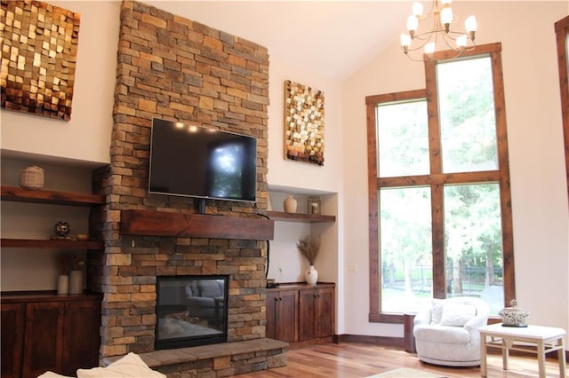 6822 Woodstock Ct, Shawnee, KS 66218 - living area featuring wood finished floors, a chandelier, a stone fireplace, and lofted ceiling