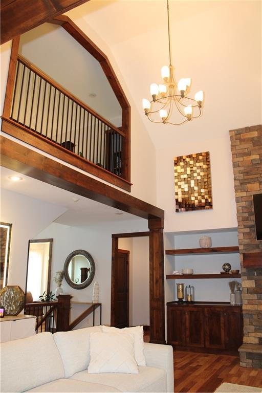 6822 Woodstock Ct, Shawnee, KS 66218 - living room with wood finished floors, a towering ceiling, and a chandelier