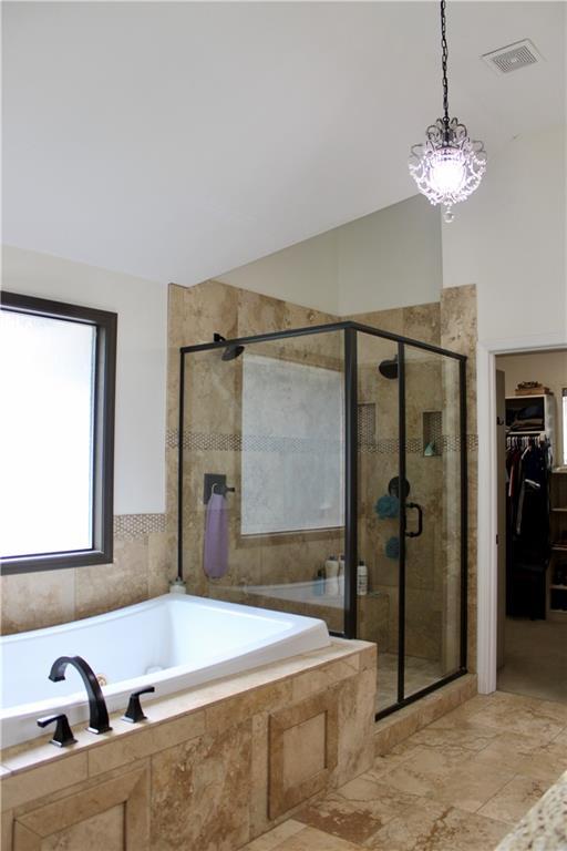 6822 Woodstock Ct, Shawnee, KS 66218 - bathroom featuring a bath, a shower stall, a walk in closet, and lofted ceiling