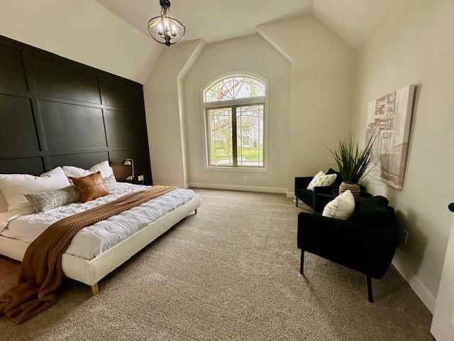 bedroom featuring light carpet, baseboards, and lofted ceiling