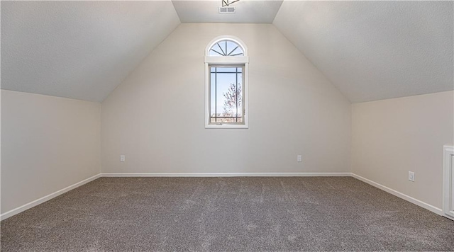 bonus room featuring baseboards, a textured ceiling, vaulted ceiling, and carpet floors