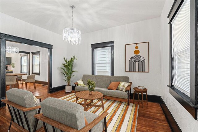 2905 Wabash Ave, Kansas City, MO 64109 - living area with baseboards, an inviting chandelier, and wood finished floors