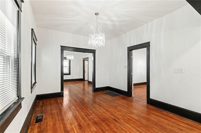 2905 Wabash Ave, Kansas City, MO 64109 - empty room featuring a chandelier, baseboards, visible vents, and hardwood / wood-style flooring