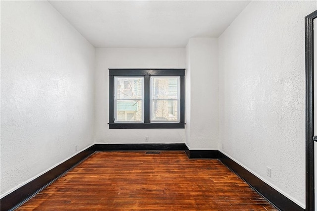 2905 Wabash Ave, Kansas City, MO 64109 - unfurnished room with visible vents, a textured wall, baseboards, and wood finished floors