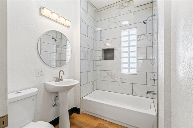 2905 Wabash Ave, Kansas City, MO 64109 - full bathroom with a sink, toilet, a textured wall, wood finished floors, and shower / tub combination
