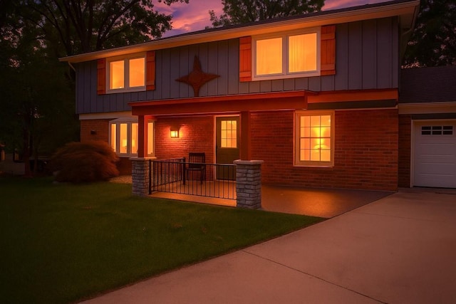 8813 W 106th Cir, Overland Park, KS 66212 - view of front of house featuring brick siding, a yard, board and batten siding, and concrete driveway