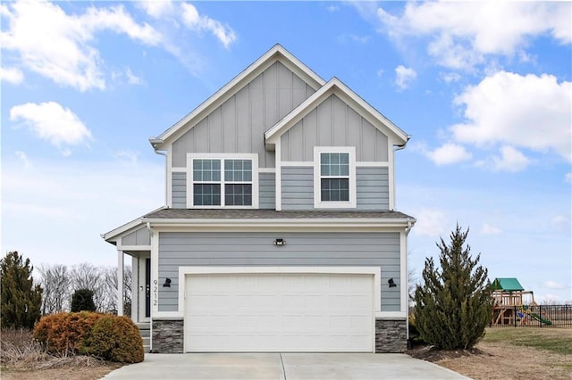craftsman house featuring stone siding, a playground, a garage, board and batten siding, and driveway