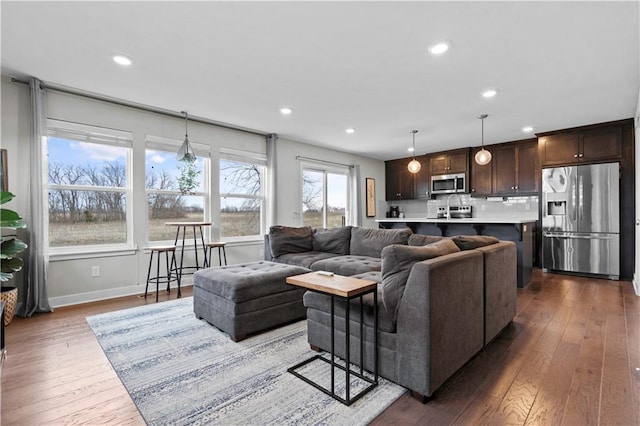 living area featuring baseboards, recessed lighting, and hardwood / wood-style flooring