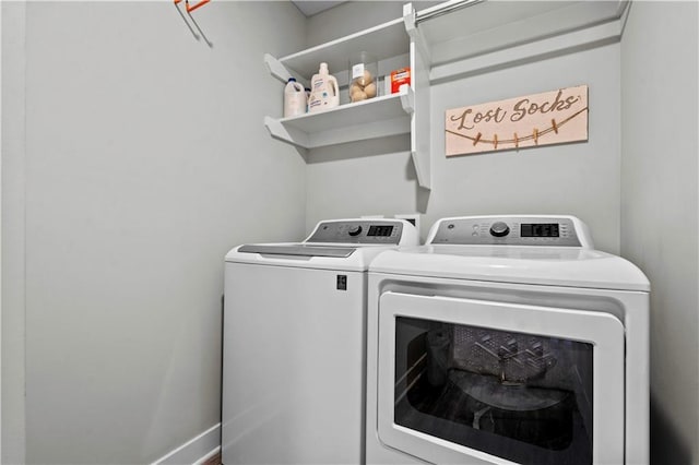 laundry area featuring washing machine and clothes dryer, baseboards, and laundry area