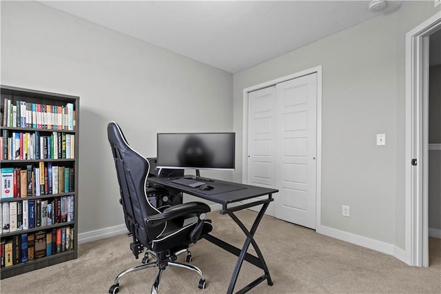 carpeted office space featuring baseboards