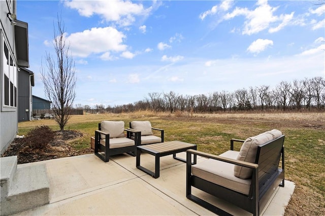 view of patio with an outdoor living space and a rural view