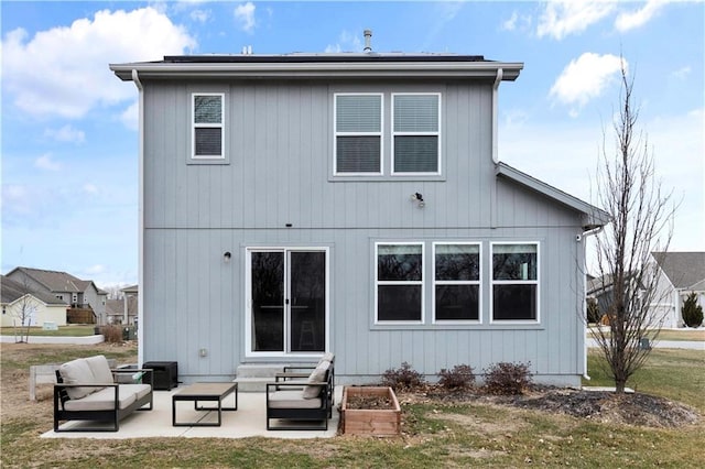 rear view of house with roof mounted solar panels and a patio area