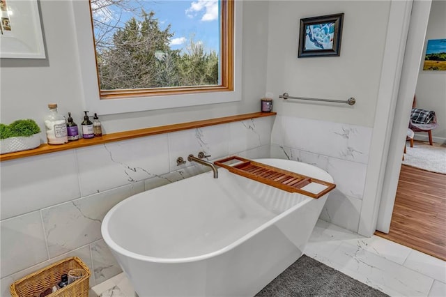 4866 Dabinawa Dr, Mclouth, KS 66054 - bathroom featuring marble finish floor, a freestanding tub, and tile walls