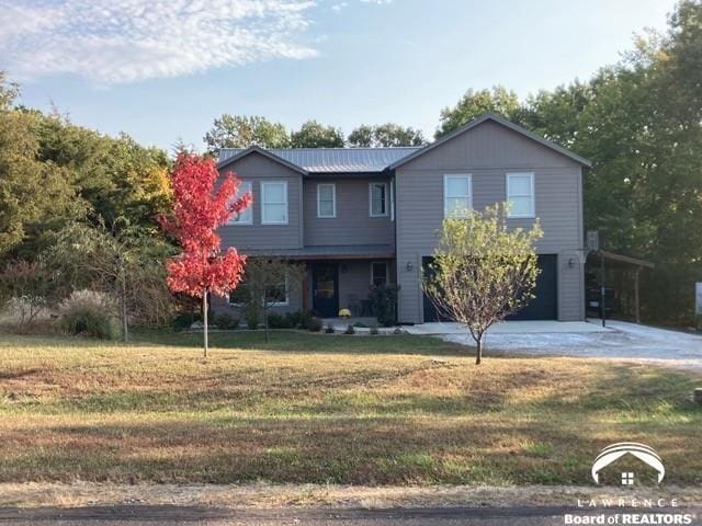 4866 Dabinawa Dr, Mclouth, KS 66054 - view of front of home with a front lawn, covered porch, an attached garage, and concrete driveway