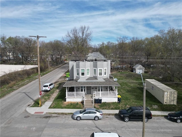 3400 E 14th St, Kansas City, MO 64127 - view of front of house featuring covered porch, stucco siding, and stairway