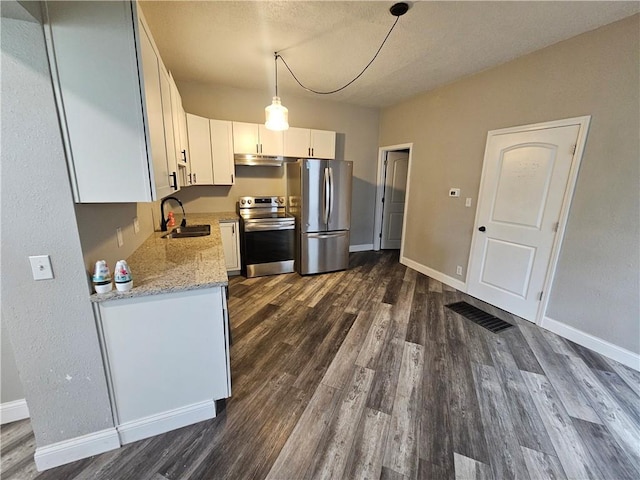 3400 E 14th St, Kansas City, MO 64127 - kitchen with appliances with stainless steel finishes, a sink, under cabinet range hood, dark wood-type flooring, and baseboards