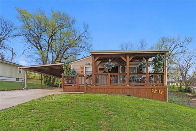 exterior space with driveway, a carport, a front yard, and fence