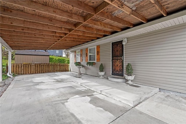 view of patio featuring fence and an outdoor structure