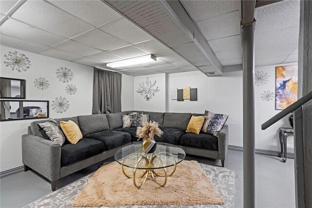 living area with concrete floors and a drop ceiling