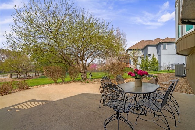 view of patio / terrace featuring central AC unit, outdoor dining space, and a residential view