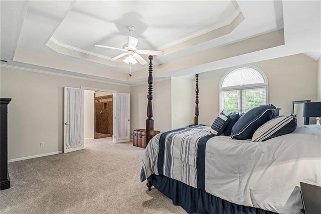 bedroom featuring a tray ceiling, carpet floors, ornamental molding, a ceiling fan, and baseboards