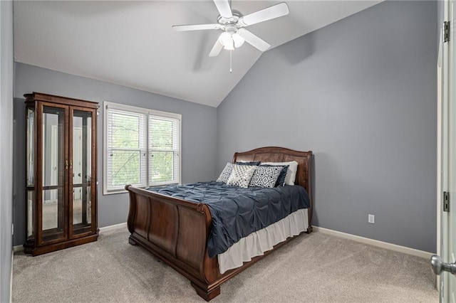 bedroom with light colored carpet, lofted ceiling, baseboards, and ceiling fan
