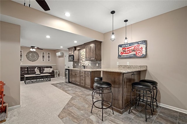 kitchen with a ceiling fan, a breakfast bar, a sink, baseboards, and recessed lighting
