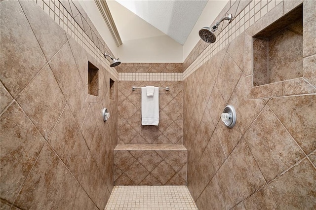 full bath with lofted ceiling, a tile shower, and a textured ceiling