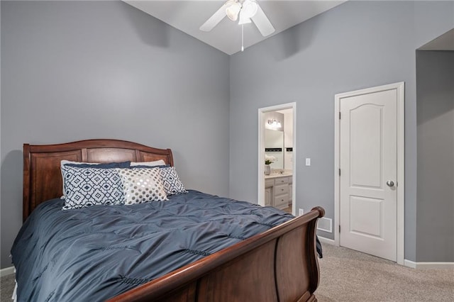 bedroom with light carpet, high vaulted ceiling, ensuite bath, baseboards, and a ceiling fan