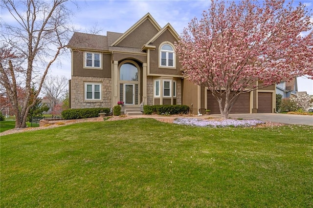 traditional-style house with driveway, stone siding, a front yard, and stucco siding