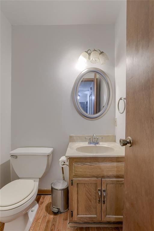 bathroom with vanity, baseboards, toilet, and wood finished floors