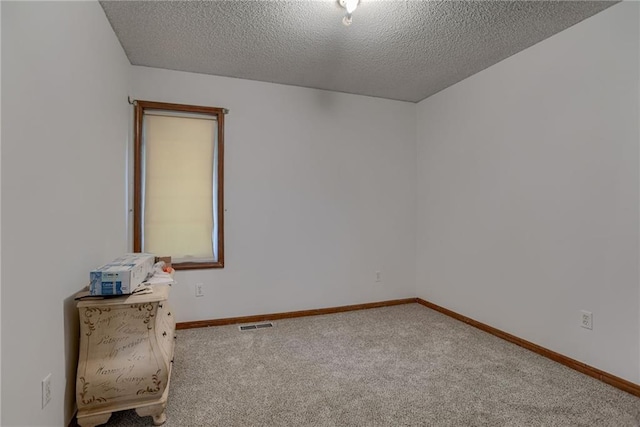 empty room with baseboards, carpet flooring, and a textured ceiling