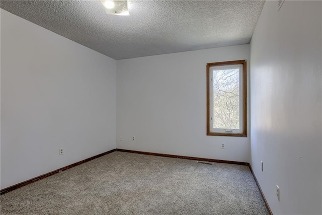 spare room featuring visible vents, baseboards, and carpet
