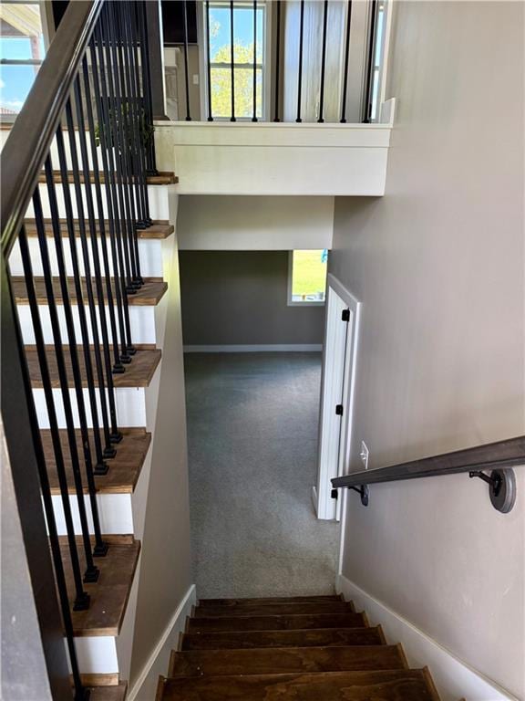 stairs featuring carpet flooring, baseboards, and a healthy amount of sunlight