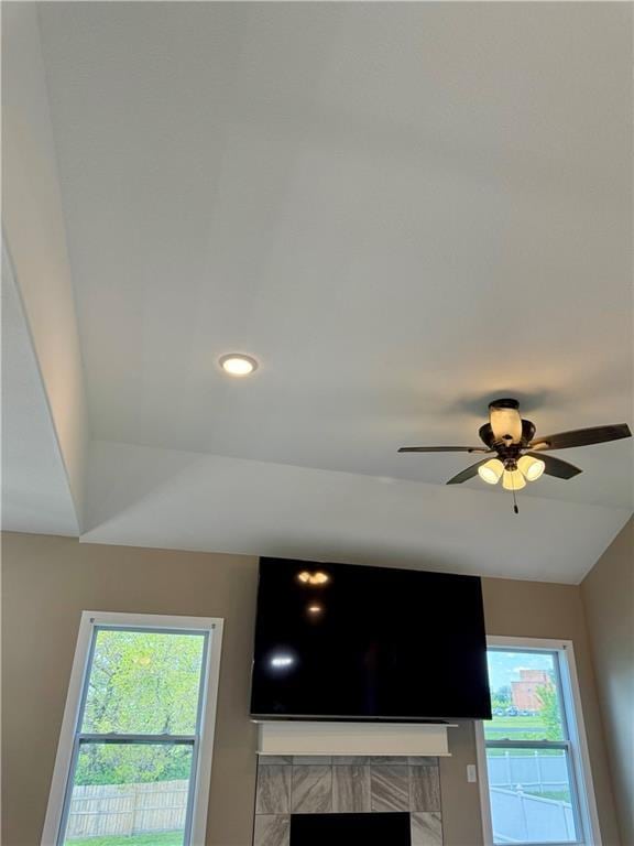interior details with a ceiling fan, a tile fireplace, and recessed lighting